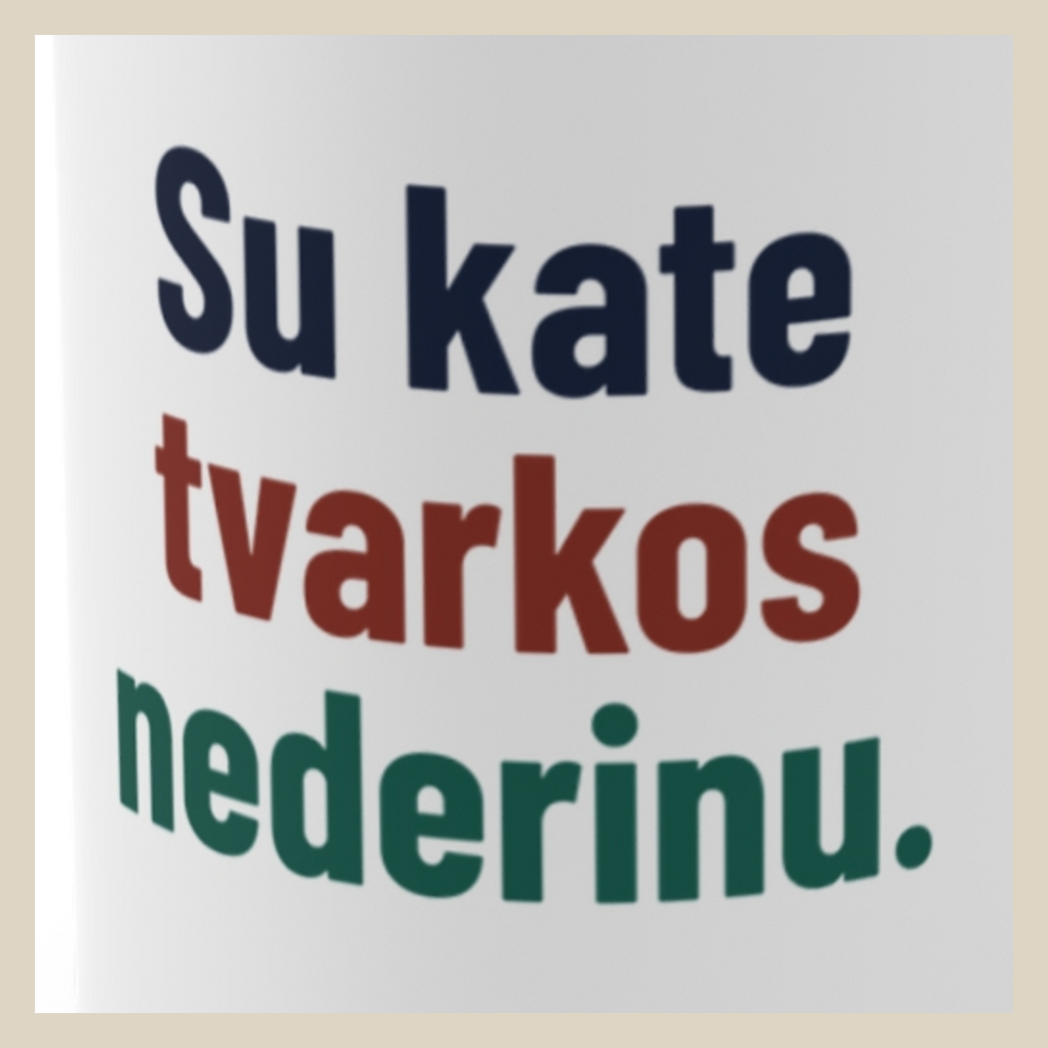 Su kate tvarkos nederinu. · Puodelis · Užrašo stambus planas